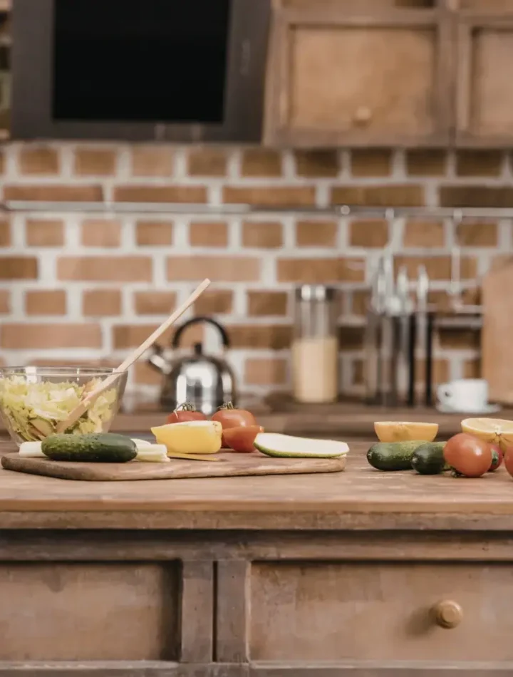 Bancada de cozinha com diversos vegetais coloridos e potes de vidro organizados para o preparo de refeições.